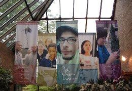 Oversized cloth banners hanging in an indoor space for branding and visual impact. Ideal for churches, events, and large venue displays.