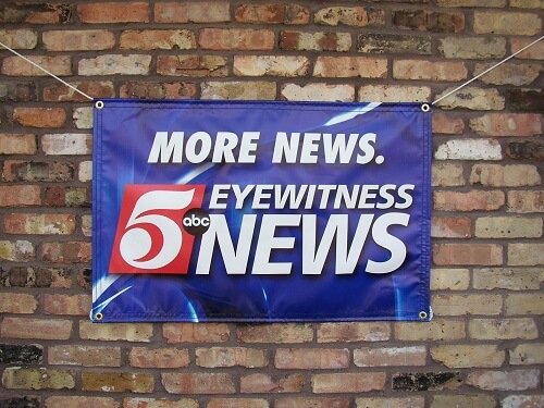 Fabric banner mounted with grommets for indoor display. Great for promotional signage, branding, and temporary wall graphics.